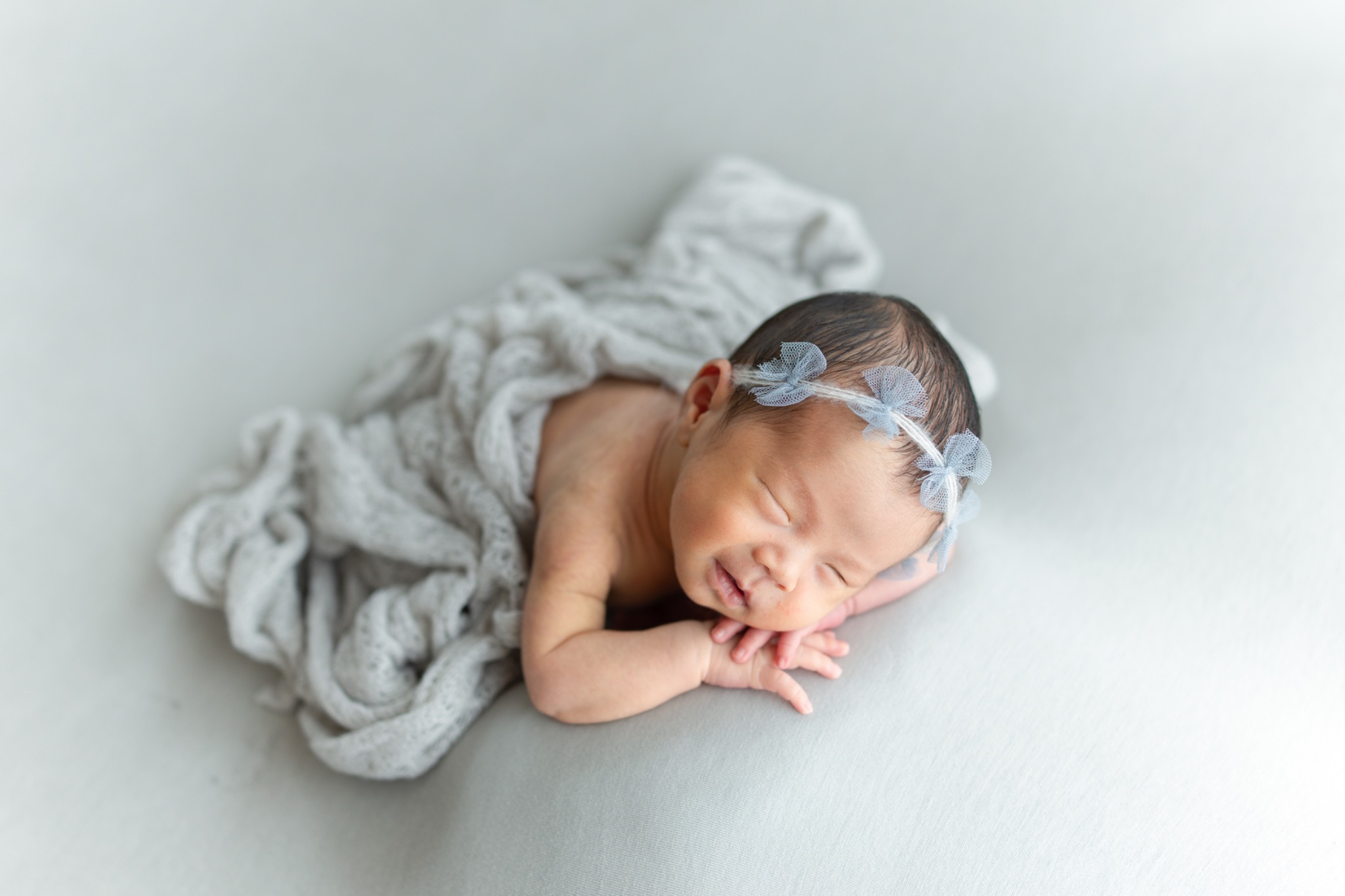 淡いブルーのリボンをつけて眠る赤ちゃん