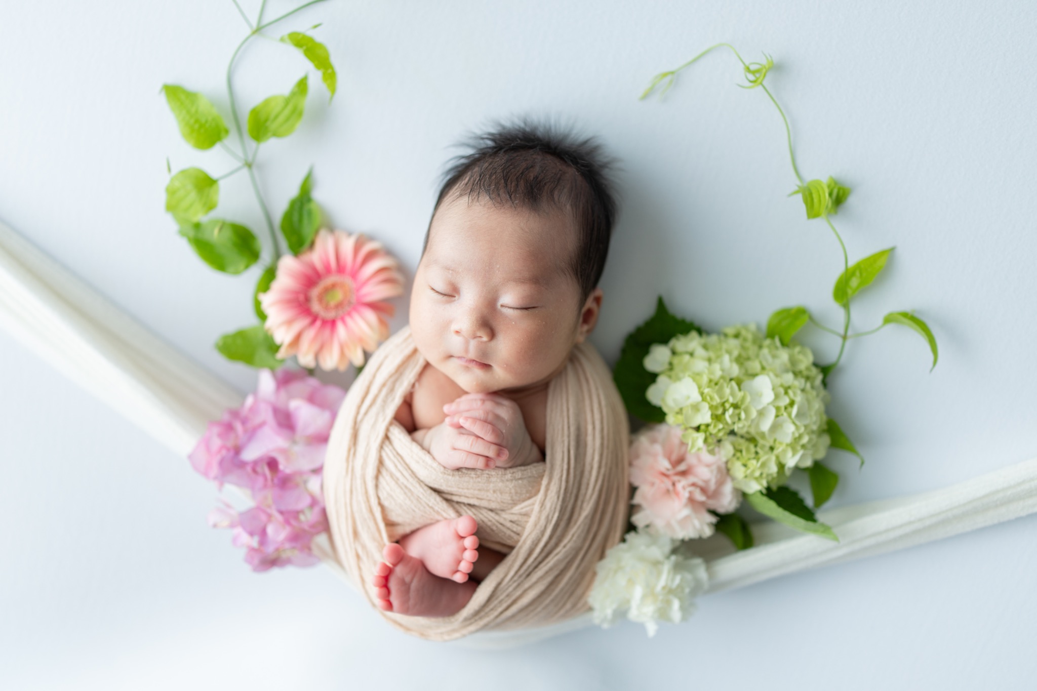 生花に囲まれて眠る赤ちゃん